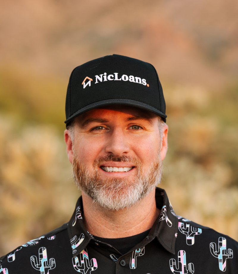 Nic Feinstein outside in the Arizona desert, wearing a NicLoans cap
